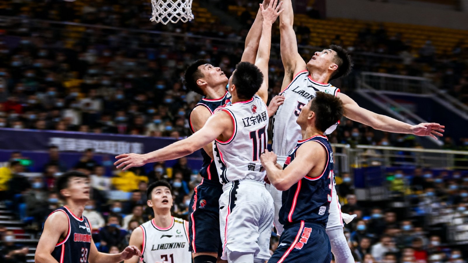 CBA季后赛辽宁队与广东队激烈对抗，球员争抢篮板